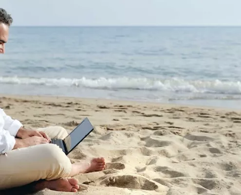 Available developer from India sitting on a beach