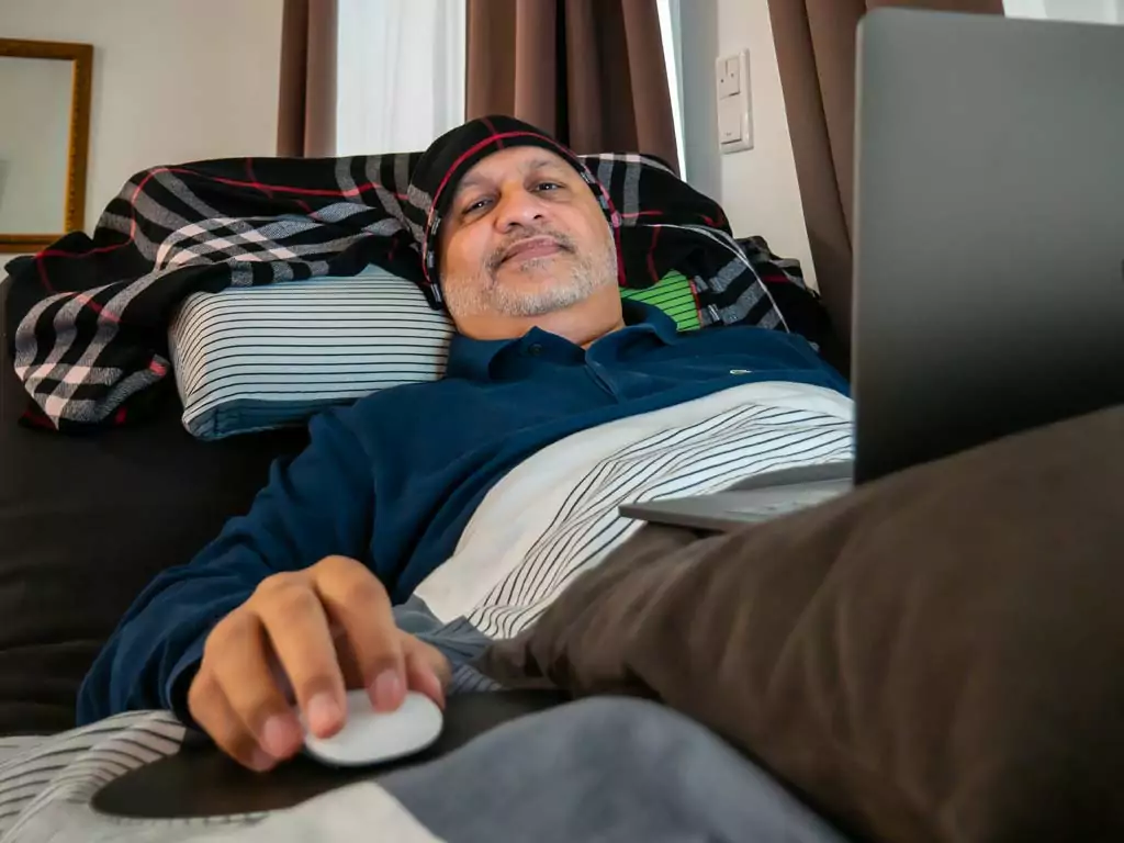 Khalid Nadeem Arif at work. Due to the chronic fatigue syndrome, he can almost only work lying down.